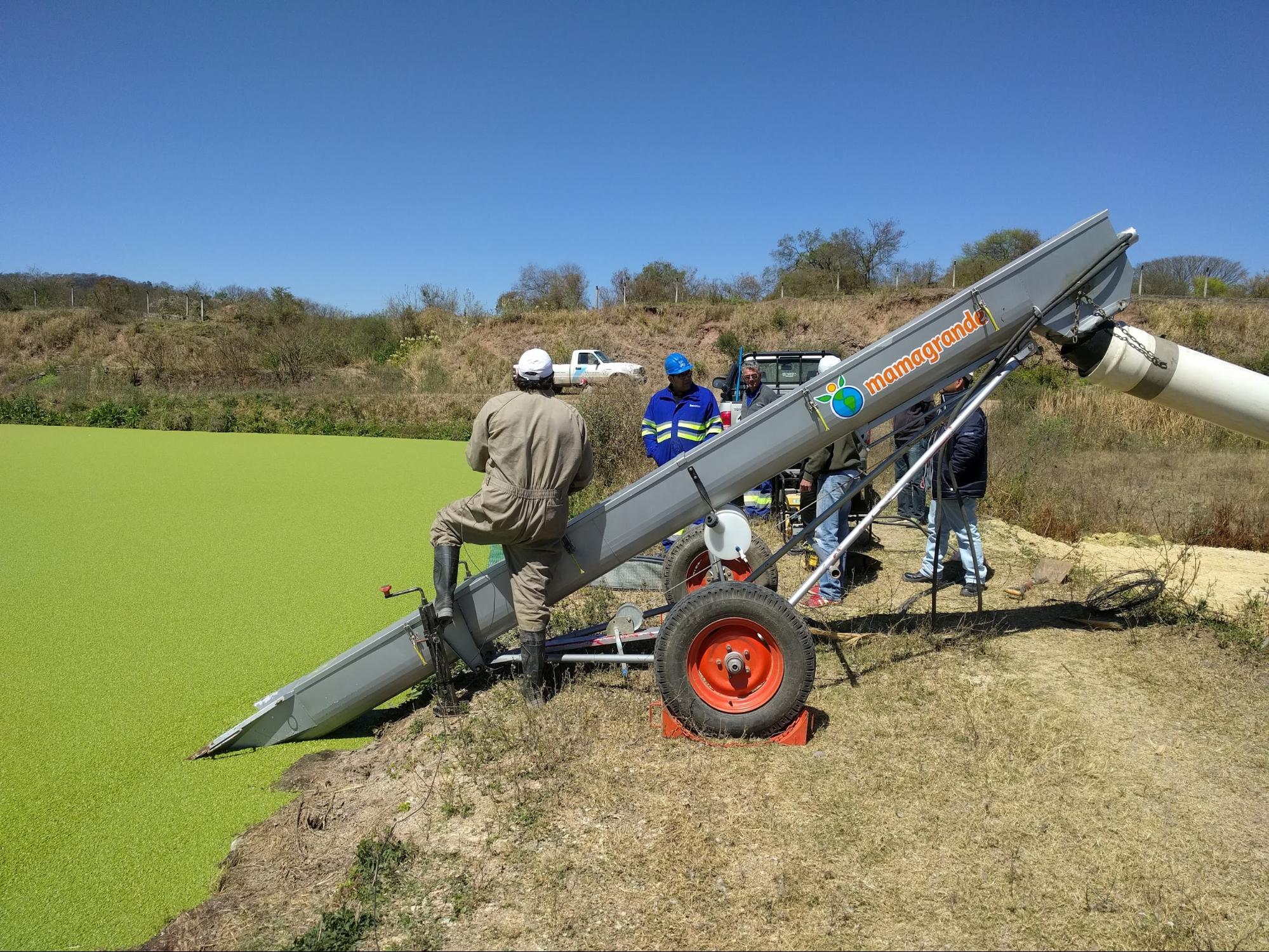 Operarios de Aguas del norte (en Salta) con un cosechador de lemnaceae.